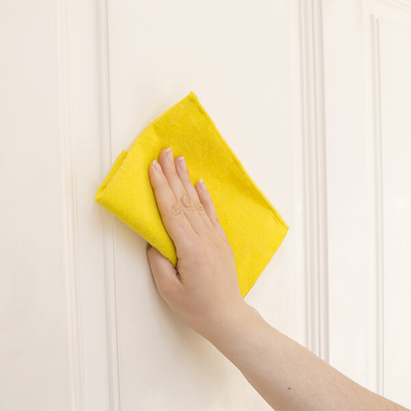 Cleaning a white wooden door with a microfibre cloth