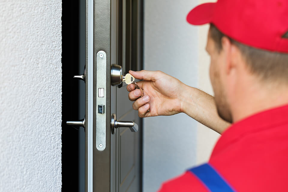 A locksmith working on a sticky lock on a door 