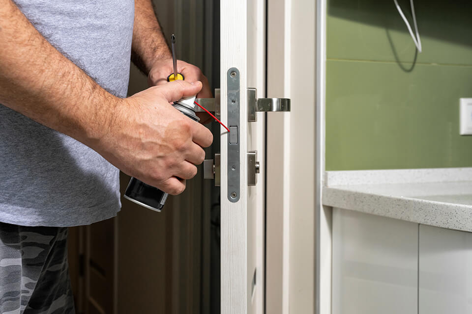 Using a lubricating spray on a door