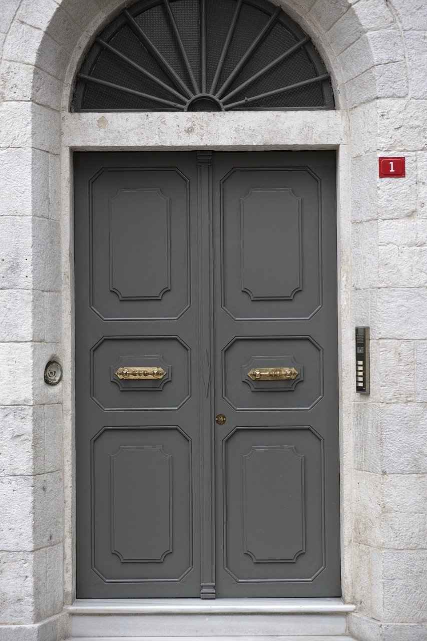 Grey front door amidst stone bricks