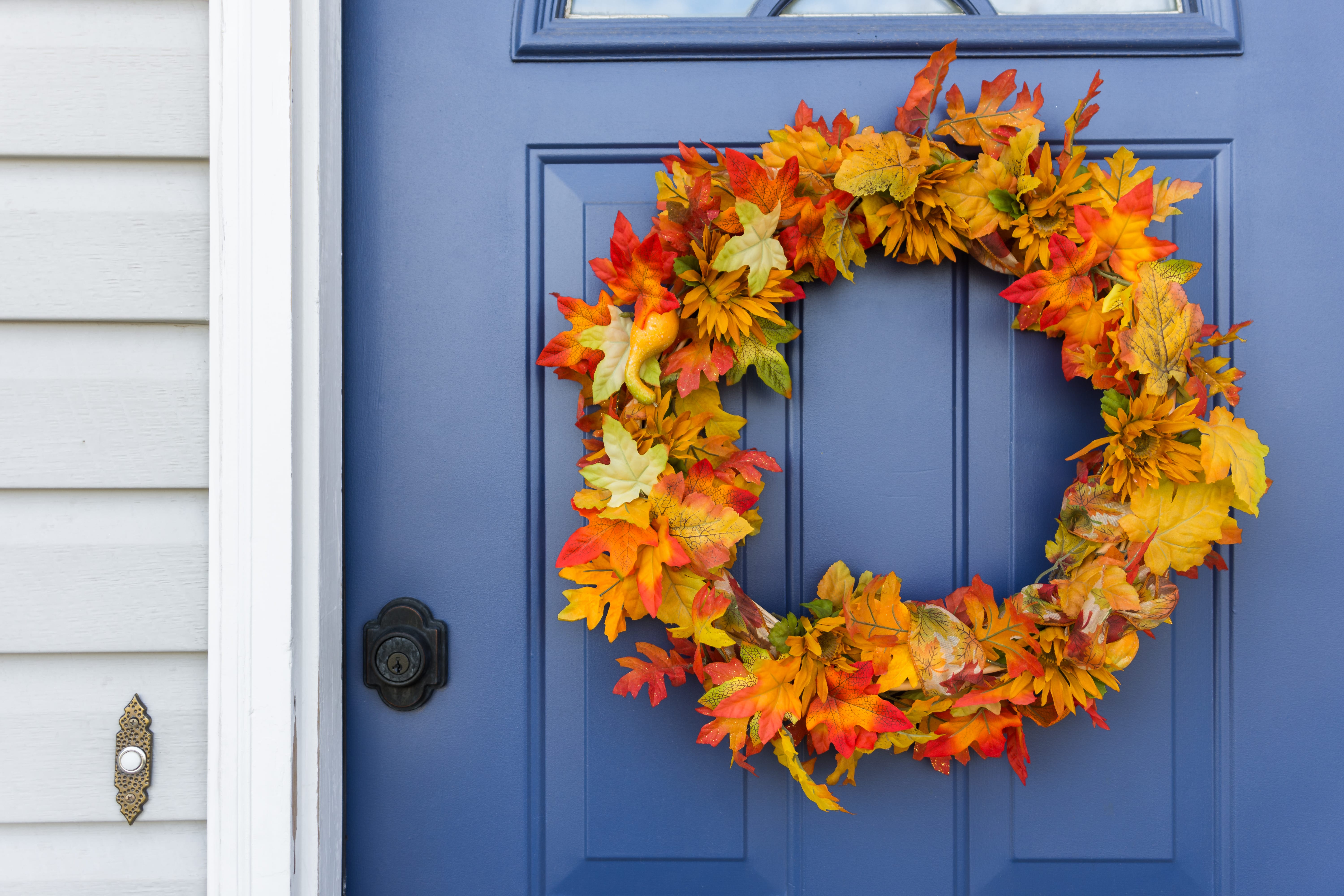 autumnal leaf wreath hanging on blue door