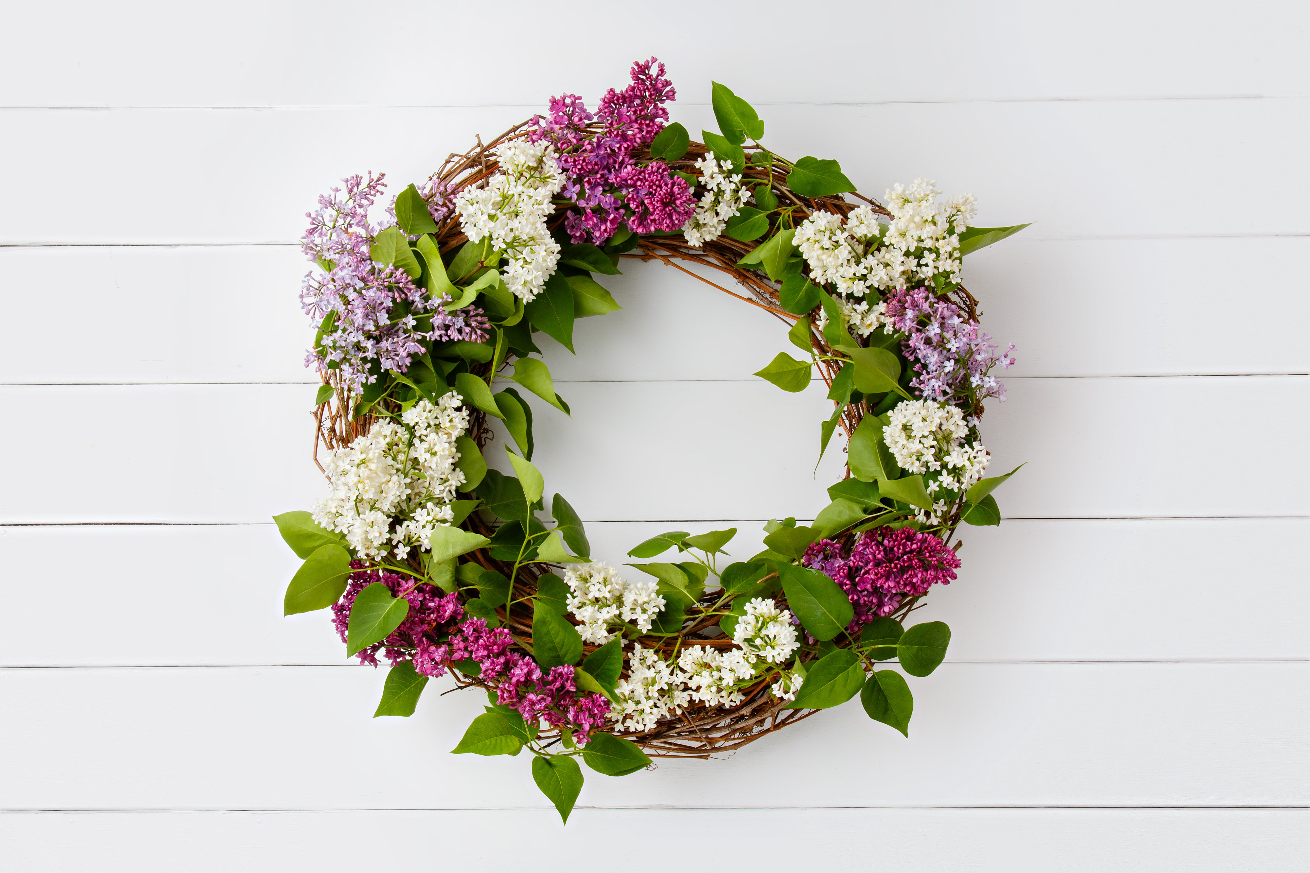 summer wreath made of purple flowers hangs on front door